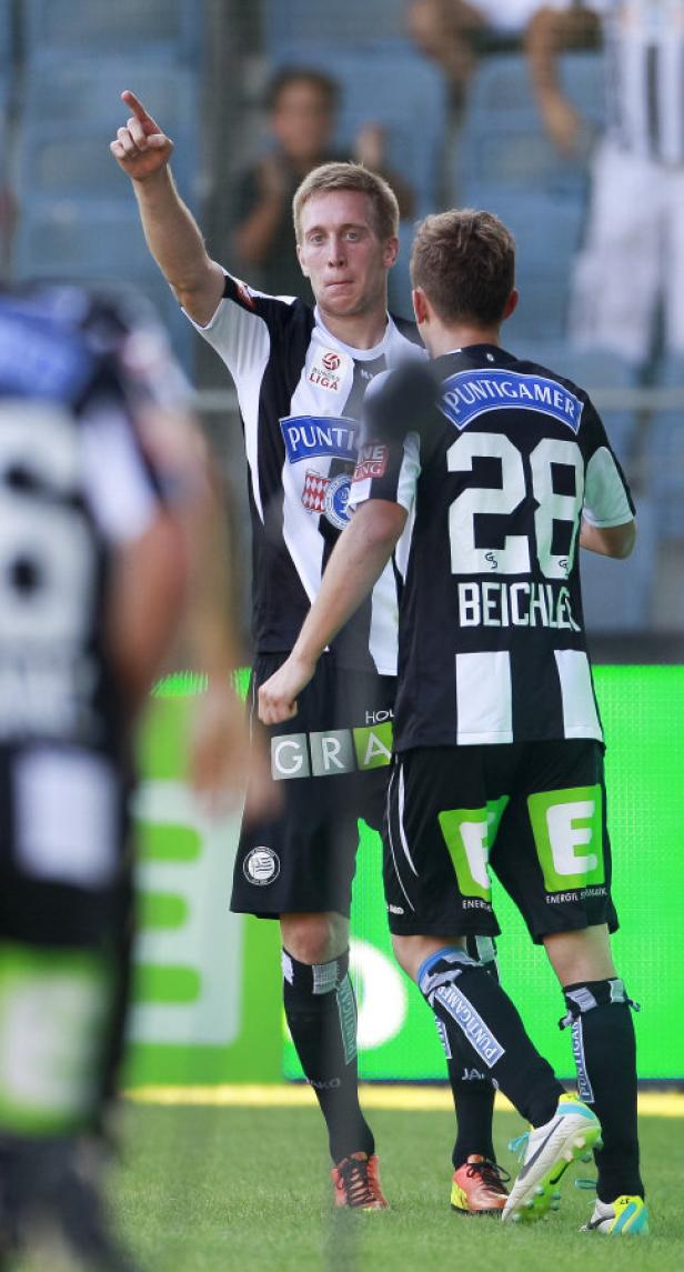 Ein Fußballspieler im schwarz-weißen Trikot jubelt mit erhobenem Zeigefinger.
