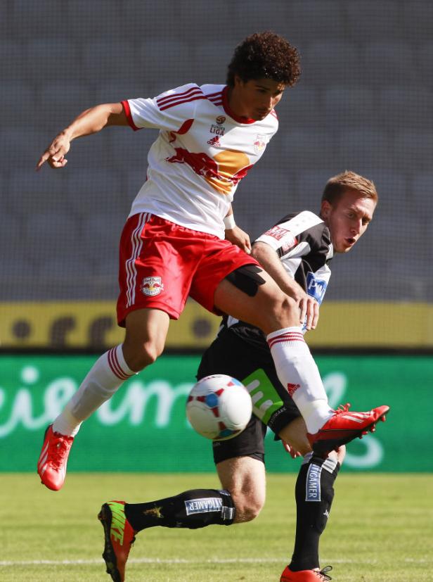 Zwei Fußballspieler kämpfen um den Ball während eines Spiels.