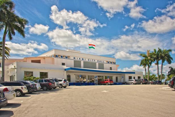 Das Rathaus von Miami an einem sonnigen Tag mit blauem Himmel und Palmen.