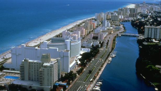 Luftaufnahme von Miami Beach mit Hotels, Strand und einem Kanal.