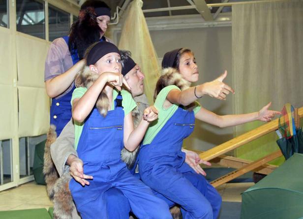 Eine Gruppe von Schauspielern in Kostümen auf einer Bühne.