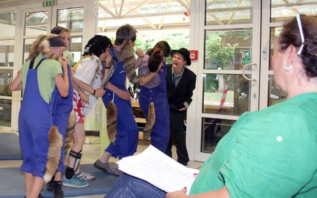 Eine Gruppe von als Tiere verkleideten Personen bei einer Theateraufführung.