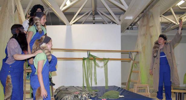 Eine Gruppe von Schauspielern in Kostümen auf einer Bühne während einer Aufführung.