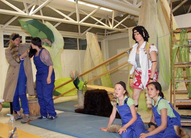 Eine Gruppe von Personen in Kostümen auf einer Bühne während einer Theateraufführung.