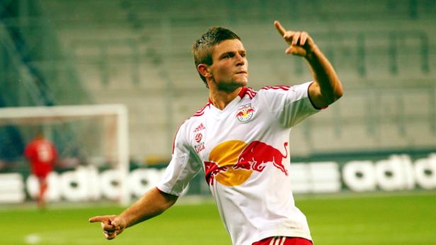 Ein Fußballspieler im Trikot von Red Bull Salzburg jubelt auf dem Spielfeld.