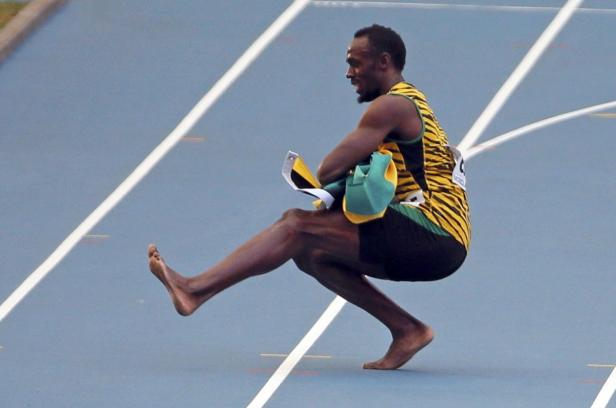 Usain Bolt barfuß auf einer blauen Laufbahn.