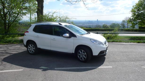Ein weißer Peugeot 2008 parkt mit Blick auf Wien.