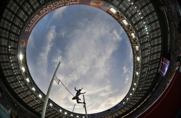 Eine Stabhochspringerin überquert die Latte in einem Stadion.
