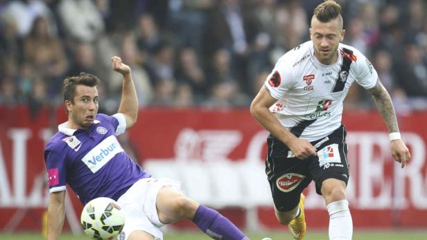 Zwei Fußballspieler kämpfen um den Ball während eines Spiels.