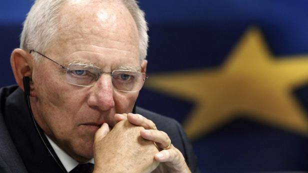 File photo of German Finance Minister Schaeuble Wolfgang Schäuble vor einer Europaflagge mit den Händen vor dem Mund.