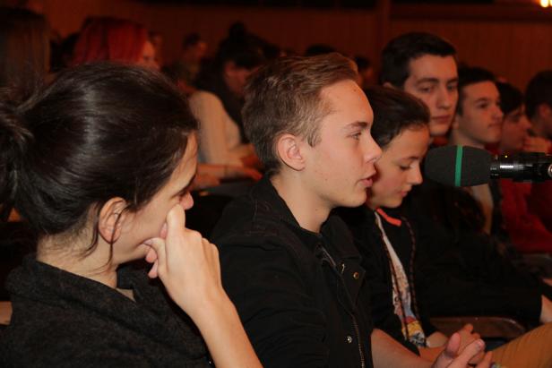 Eine Gruppe junger Leute sitzt bei einer Podiumsdiskussion im Publikum.