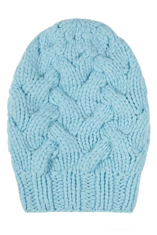 Eine hellblaue, gestrickte Mütze mit Zopfmuster.