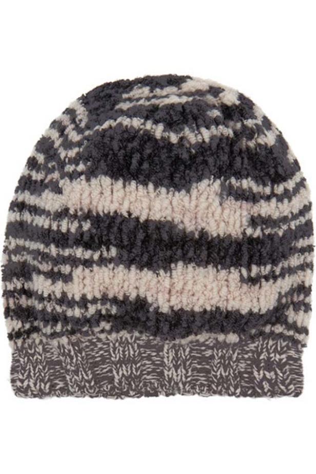 Eine gestreifte, gehäkelte Mütze in Grau- und Beigetönen.