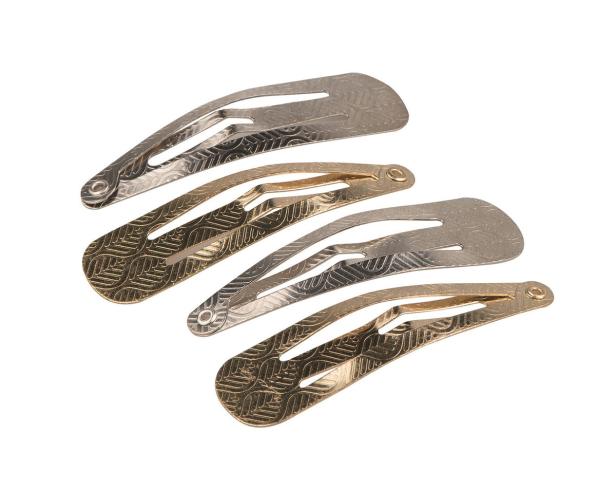 Mehrere goldene und silberne Haarspangen liegen auf einem weißen Hintergrund.