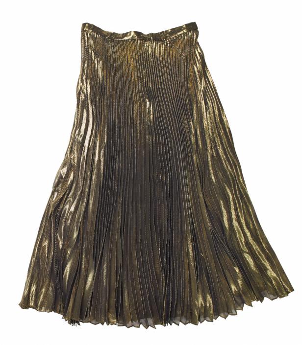 Ein goldener, plissierter Rock liegt auf einem weißen Hintergrund.