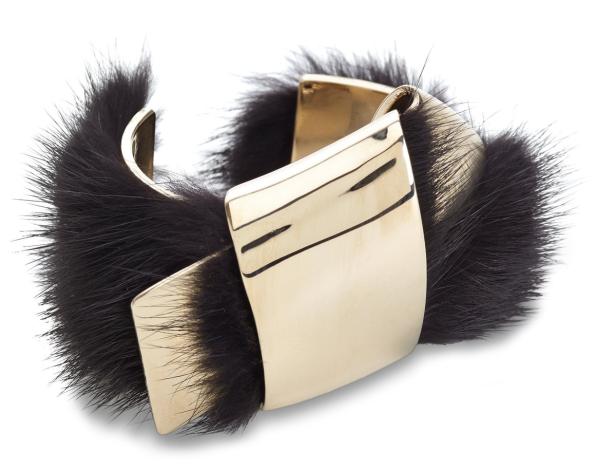 Ein goldenes Armband mit schwarzem Fellbesatz.
