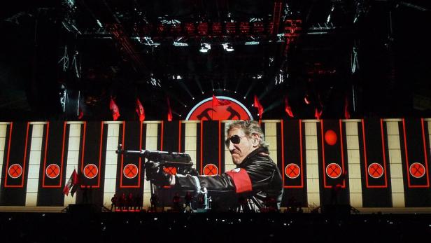 Roger Waters zielt während eines Konzerts mit einer Maschinenpistole auf das Publikum.