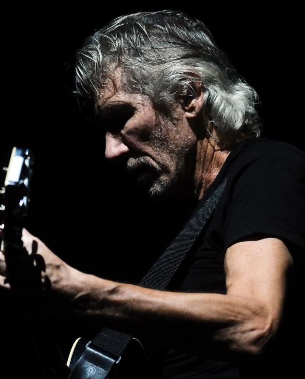 Roger Waters spielt Gitarre während eines Konzerts.