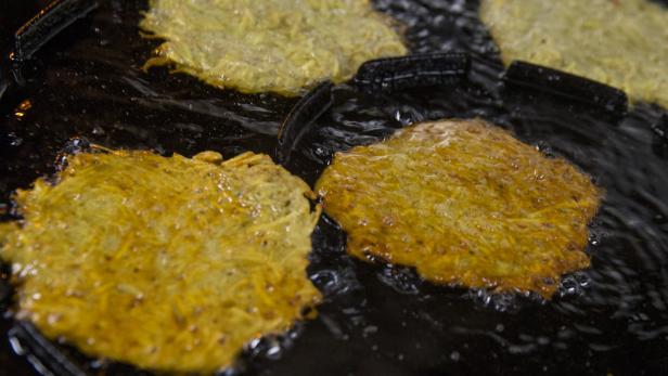 Kartoffelpuffer werden in heißem Öl gebraten.