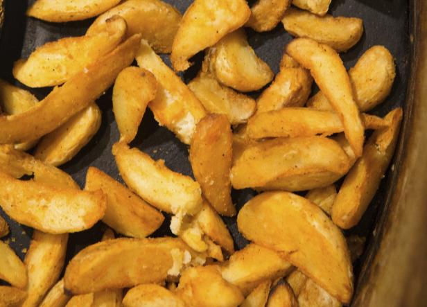 Eine Schale mit goldgelben Kartoffelspalten.