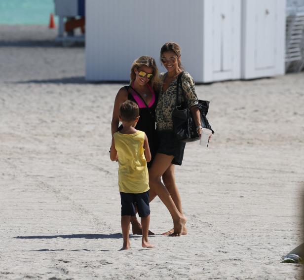 Zwei Frauen und ein Kind stehen am Strand.