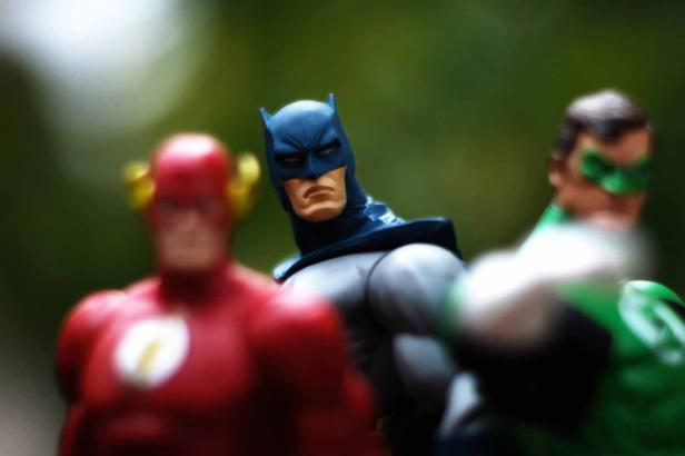 Spielzeugfiguren von Batman, Flash und Green Lantern stehen zusammen.