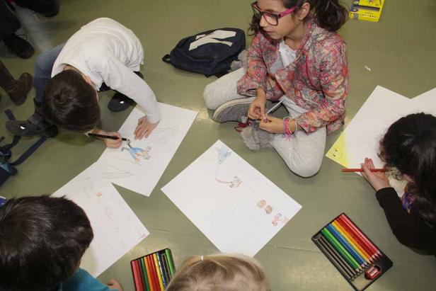 Kinder sitzen auf dem Boden und malen mit Buntstiften auf Papier.