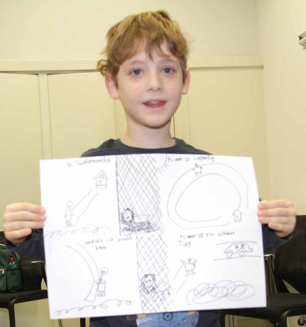 Ein Junge präsentiert eine selbstgezeichnete Comic-Geschichte.