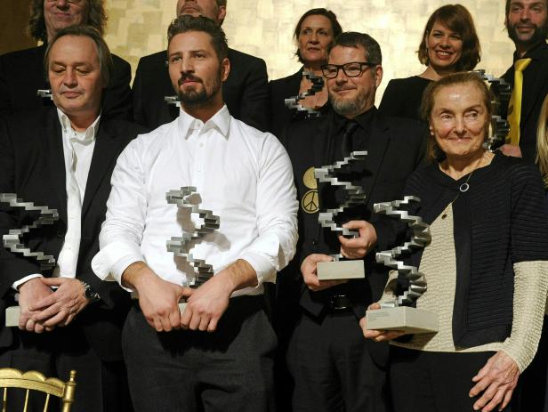 Mehrere Personen halten eine spiralförmige Skulptur in den Händen.