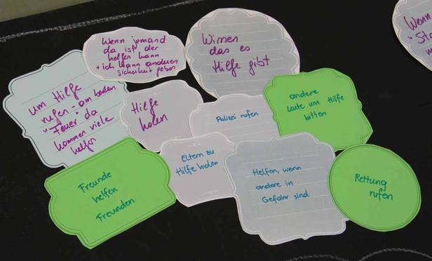 Auf einem schwarzen Hintergrund liegen Zettel mit handgeschriebenen Tipps, wie man Hilfe bekommt.