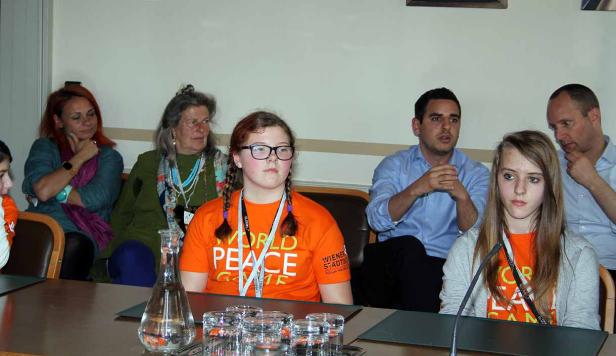 Eine Gruppe von Menschen sitzt an einem Tisch während einer Veranstaltung.