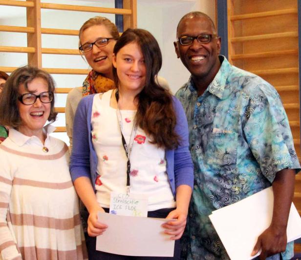 Eine Gruppe von vier Personen lächelt in die Kamera.