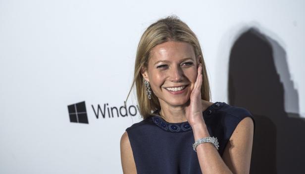 Gwyneth Paltrow lächelt auf einer Veranstaltung vor einem Windows-Logo.