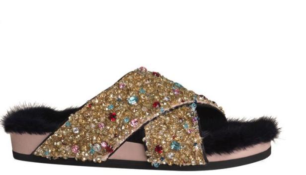 Ein mit goldenen Pailletten und bunten Juwelen besetzter Hausschuh mit Fellbesatz.