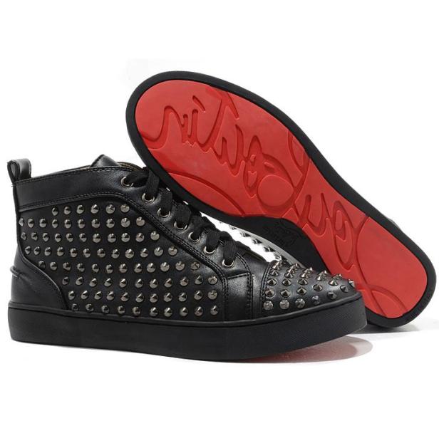 Ein Paar schwarze, nietenbesetzte High-Top-Sneakers mit roten Sohlen.