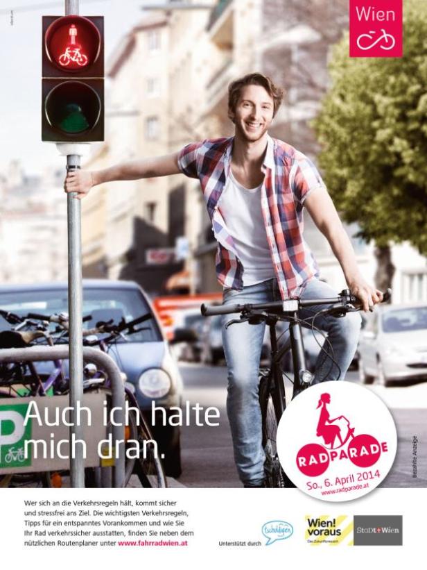 Ein lächelnder Mann auf einem Fahrrad wartet an einer roten Ampel in Wien.