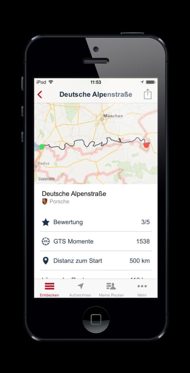 Auf dem Display eines Smartphones ist die App „Deutsche Alpenstraße“ von Porsche zu sehen.