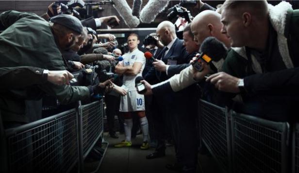 Wayne Rooney - Nike Risk Everything Wayne Rooney umringt von Reportern und Mikrofonen.
