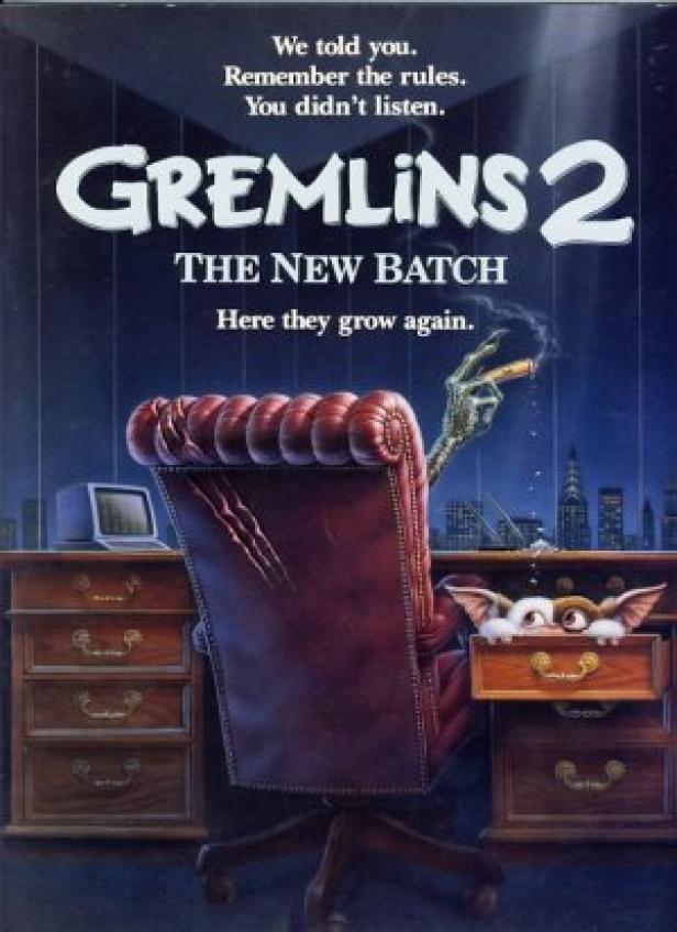 Das Filmplakat für „Gremlins 2: The New Batch“ zeigt einen Gremlin am Schreibtisch mit Zigarre.