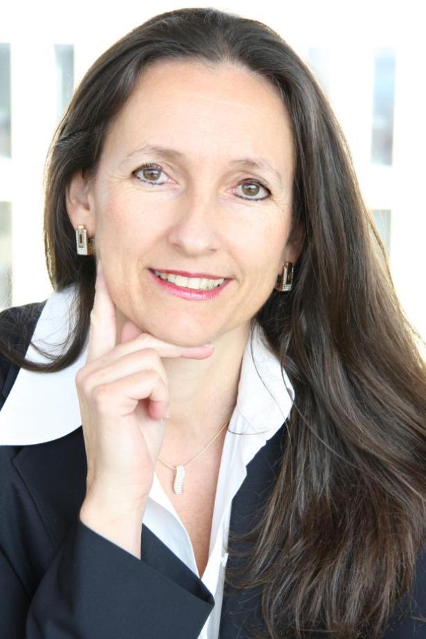Gabriele Zelloth, Geschäftsführerin Megaboard, weitet das Werbeträger-Netz in der frequenzstarken, urbanen Umgebung von Graz aus. (c: megaboard) Eine Frau in einem dunklen Blazer und weißer Bluse lächelt und hält ihre Hand ans Kinn.