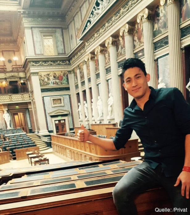 Ein Mann sitzt im österreichischen Parlament und zeigt einen Daumen nach oben.