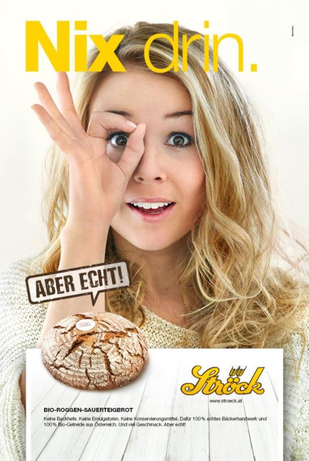 Eine Frau blickt durch ein „Okay“-Zeichen auf ein Bio-Roggen-Sauerteigbrot der Bäckerei Ströck.