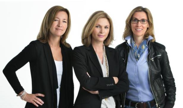 Drei Frauen posieren vor einem weißen Hintergrund.