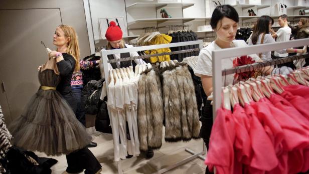 Kundinnen wählen Kleidung in einem Bekleidungsgeschäft aus.
