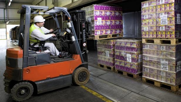 Ein Gabelstaplerfahrer transportiert Paletten mit „Whiskas Junior“-Katzenfutter in einem Lagerhaus.