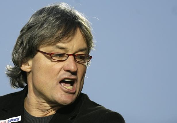 Ein Mann mit Brille und grauem Haar schreit.