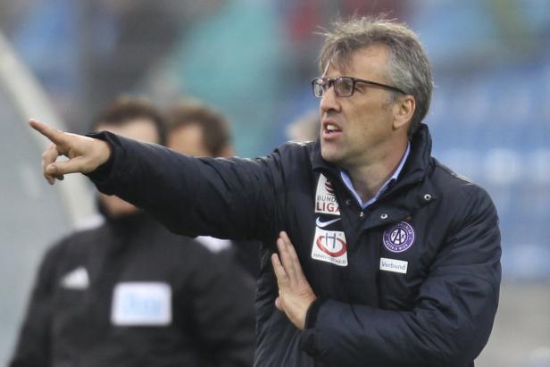 Ein Trainer mit Brille gestikuliert während eines Fußballspiels.