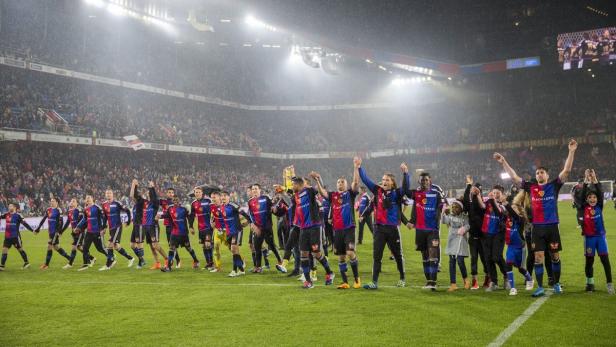 Die Mannschaft des FC Basel feiert auf dem Rasen vor der Fankurve.
