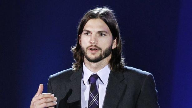 Ashton Kutcher spricht auf einer Bühne.
