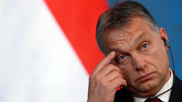 Viktor Orbán blickt nachdenklich mit dem Finger an der Stirn.